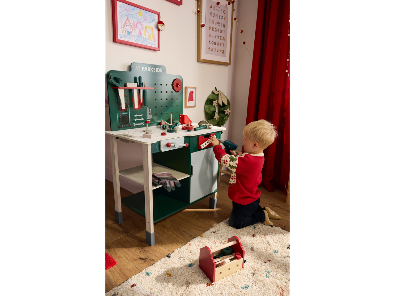 A child plays with a Lupilu wooden toy workbench, featuring various tools and accessories.