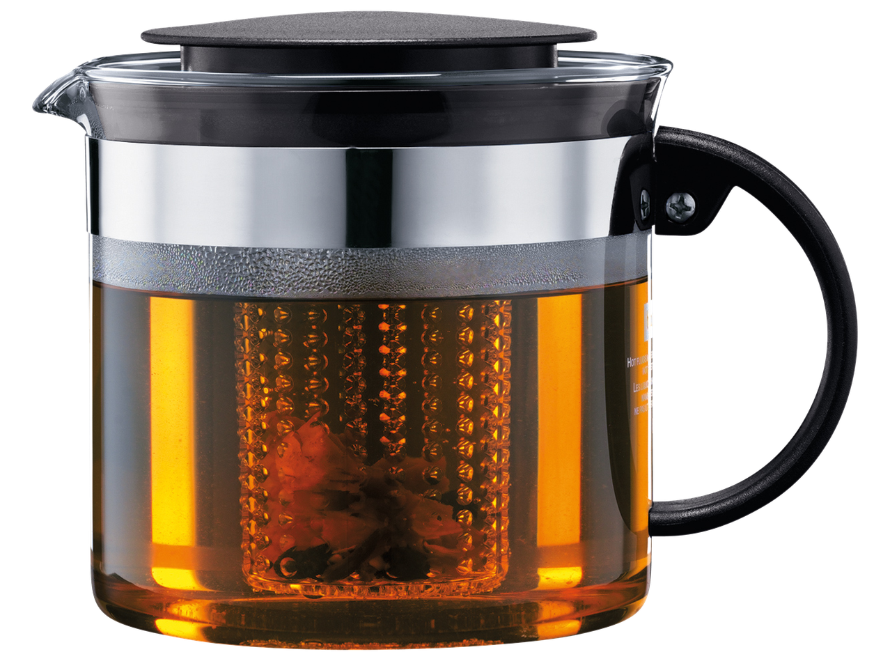 Стъклена кана за чай с инфузер, пълна с кехлибарен чай, на черен фон.