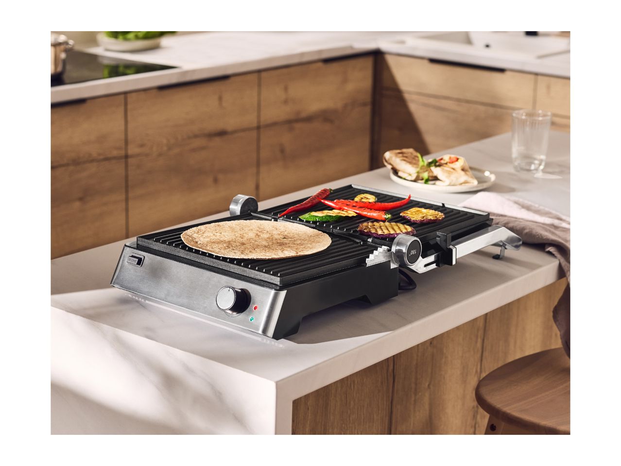Electric grill with vegetables and tortilla on a kitchen counter