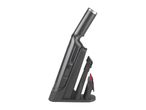 A Dyson cordless vacuum cleaner and its attachments are neatly stored in its docking station.