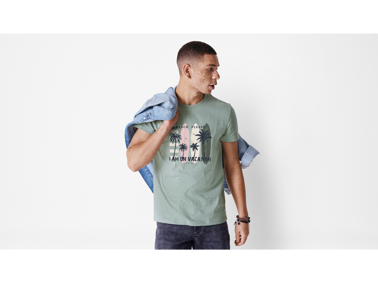 Model masculin purtând un tricou verde Jack & Jones cu imprimeu de plajă.