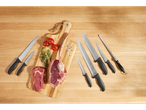 Conjunto de facas de açougueiro SILVERCREST® com carne crua e ervas numa tábua de madeira