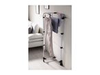 White clothes drying rack with various garments, including trousers and a striped shirt.