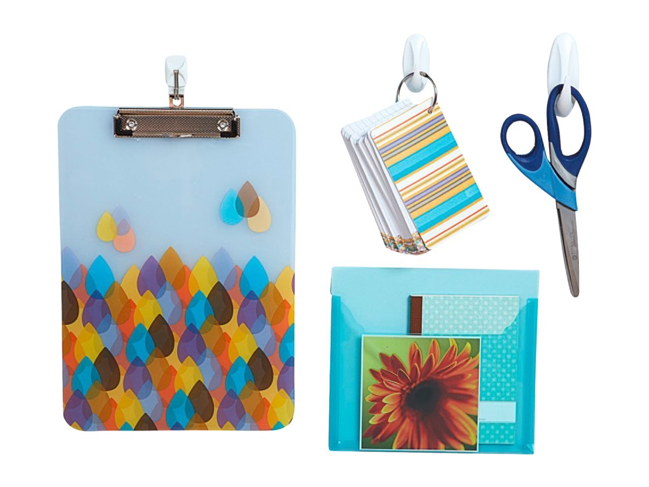 A clipboard, note cards, scissors, and a wall pocket, all hanging from hooks.