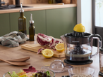 Сокоизстисквачка Silvercrest на кухненски плот с лимони, салата и бутилки със зехтин.