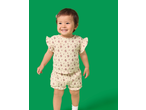 A smiling toddler in a floral print top and matching shorts.