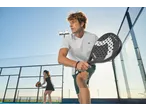 Jogadores de padel com raquetes CRIVIT num campo exterior ensolarado.