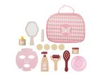 Pink toy spa set with a bag, mirror, face mask, cucumber slices, and various wooden beauty tools.