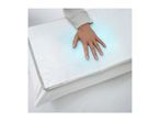 Hand on a white pillow with a cooling blue effect, on a bed.