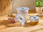 Прозрачни кръгли кутии за съхранение на храна с паста и супа на дървен плот.