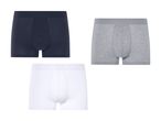Tre par boksershorts i navy, grå og hvid.