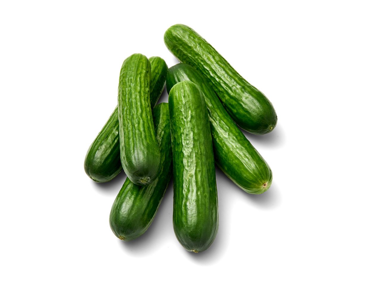 Een bosje verse groene komkommers op een zwarte achtergrond.