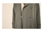 Close-up of a green double-breasted trench coat with tortoise shell buttons.