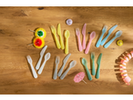 Colorful SILVERCREST® plastic cutlery sets with party decorations on a wooden table.