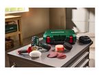 Cordless polisher with accessories, including polishing pads and sanding discs, on a metal workbench.