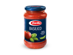 Glazen pot met tomatensaus en basilicum, met een tomaat en basilicumblaadjes op het etiket.
