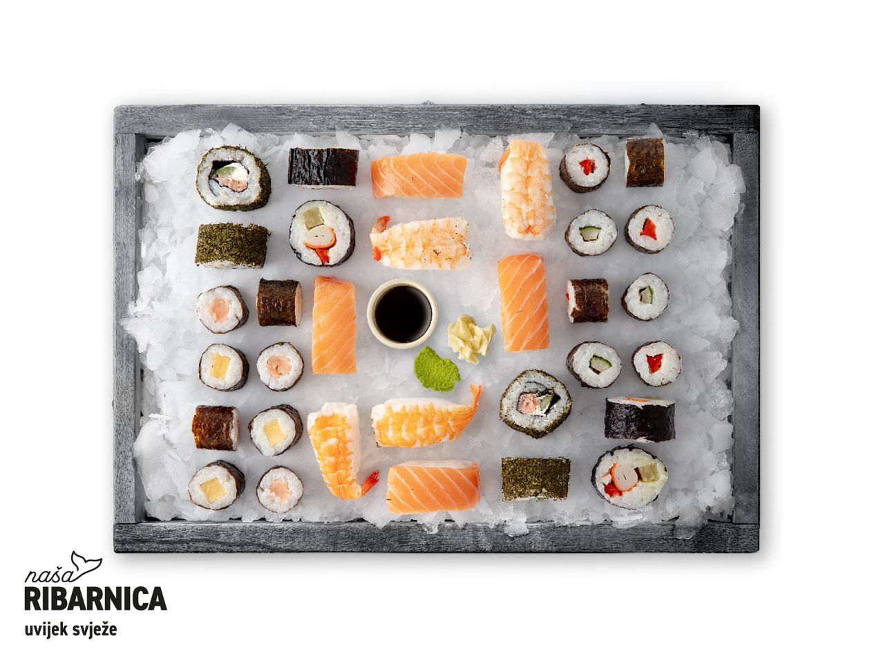 Pladanj s raznim sushijem i sashimijem na ledu, s umakom od soje i wasabijem.