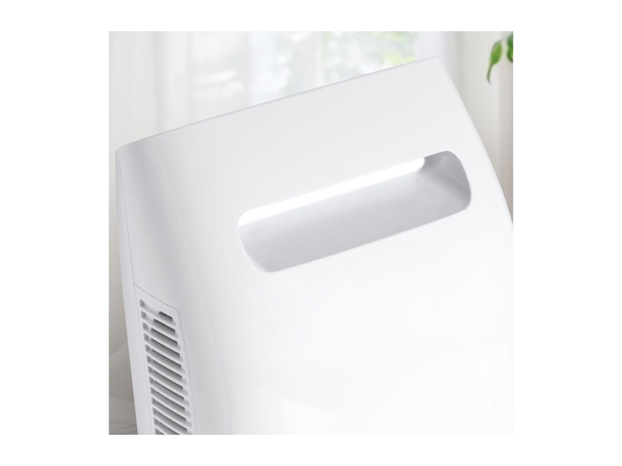 Close-up of a white air purifier with a handle and side vents.