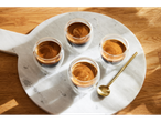 Quatro xícaras de expresso em uma bandeja de mármore.