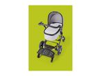 Grey baby stroller with a black ride-on board attached, on a green background.
