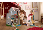 Two children playing with a wooden doll's house and furniture set.