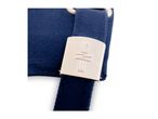 Close-up of a navy blue fabric strap with a light-colored buckle featuring embossed text.