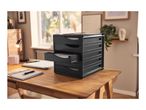 Black desk organizer with multiple drawers on a wooden desk with office supplies.