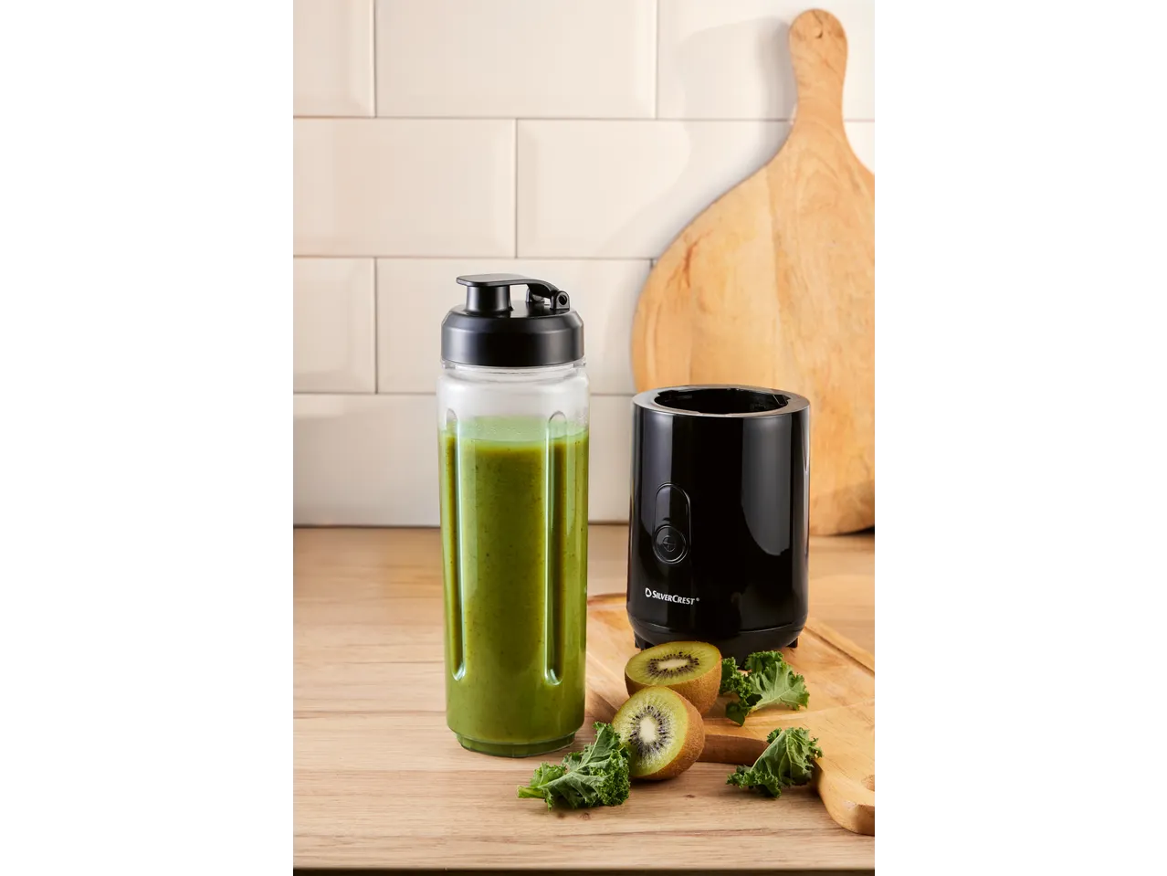 Liquidificador de batidos SILVERCREST com batido verde, kiwi e couve-galega numa tábua de madeira.