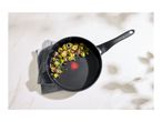 Non-stick frying pan with cooked Brussels sprouts and red onion.