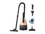 Vacuum cleaner with hose, attachments, and two replacement dust bags.