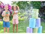 Children playing with water guns and can targets in a garden.