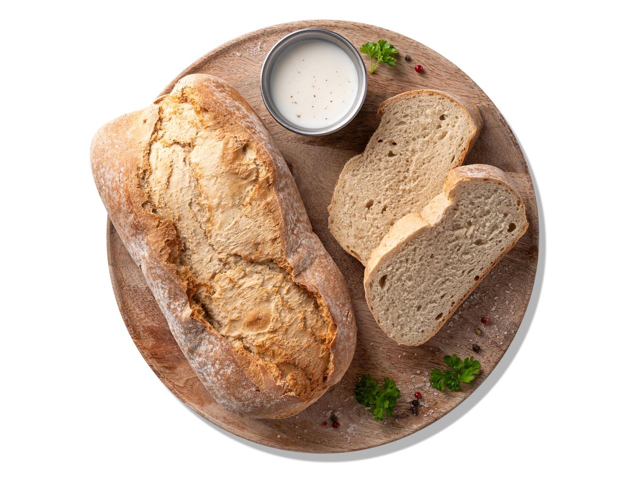 Friss kenyér, szeletelt kenyér és mártogatós egy fa tálcán.