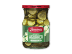 En glasburk med skivede syltede agurker, med en rød låg og grøn etiket.