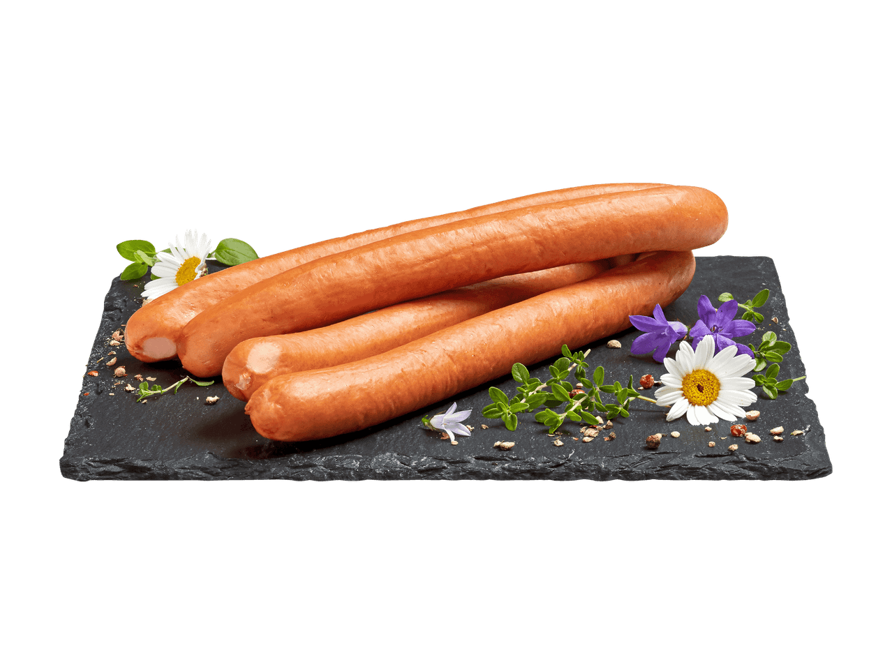 Vier Würstchen auf einer schwarzen Schieferplatte, garniert mit Blumen und Kräutern.