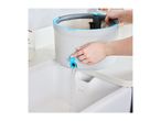 A person draining water from a grey mop bucket with blue accents into a white sink.