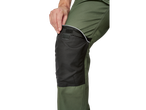 Prim-plan cu o persoană care ajustează o genunchieră la o pereche de pantaloni de lucru verzi.