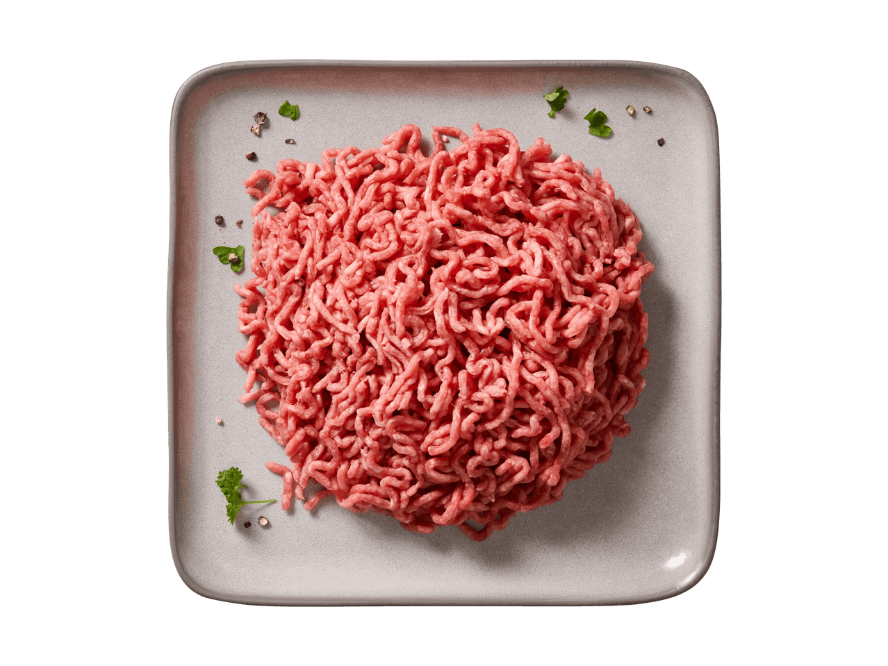 Hackfleisch auf einem grauen Teller, garniert mit Pfefferkörnern und Petersilie.