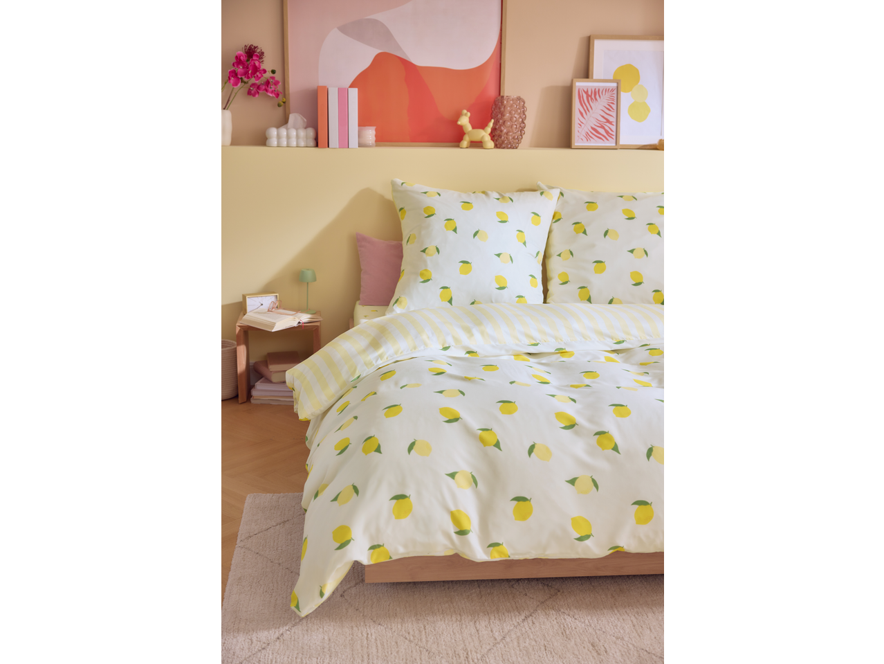 Bedroom with lemon-patterned Livarno Jersey Fitted Sheet, striped duvet, and pink accents.