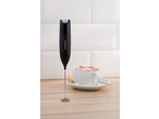 Espumador de leite SILVERCREST® preto com uma chávena de cappuccino ao fundo.