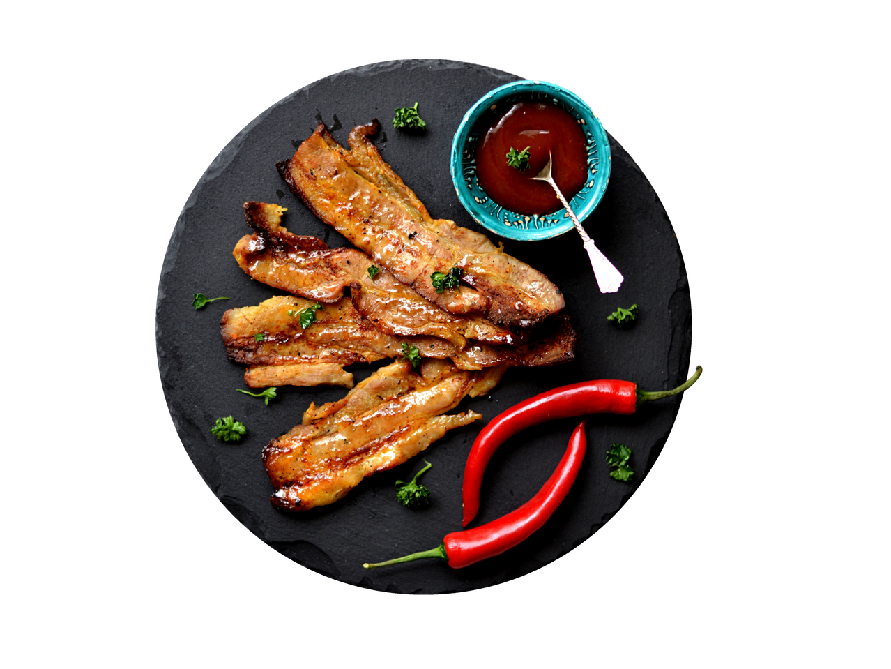 Kepta kiaulienos šoninė marinate su aitriosiomis paprikomis ir padažu ant skalūno lėkštės.
