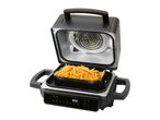 Air fryer with a basket of golden french fries, open to show the heating element.