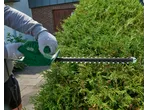 Pessoa a aparar uma sebe com um corta-sebes elétrico Parkside® de 450W.