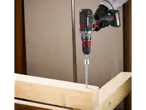 Una persona usa un trapano a batteria Parkside per avvitare in una trave di legno.