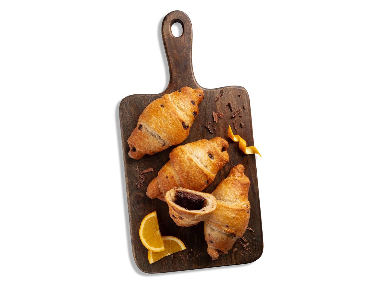 Csokoládés croissant-ok fa vágódeszkán narancsszeletekkel.