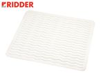 A white Ridder bath mat with a wavy pattern and drainage holes.
