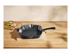 Cast iron grill pan on a wooden cutting board with vegetables.