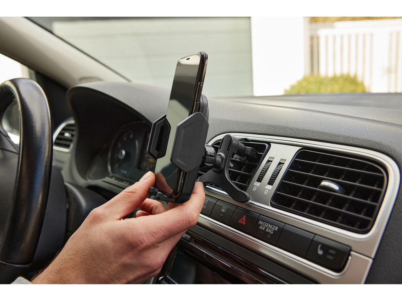Una mano posiziona un supporto per cellulare da auto su una bocchetta d'aria.