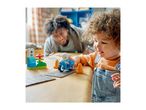 A child and adult playing with building blocks, including a toy motorcycle and traffic light.