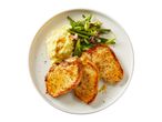Pan-seared pork chops served with mashed potatoes and green beans.
