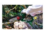 A person using a cordless garden pruning saw to cut a tree branch.